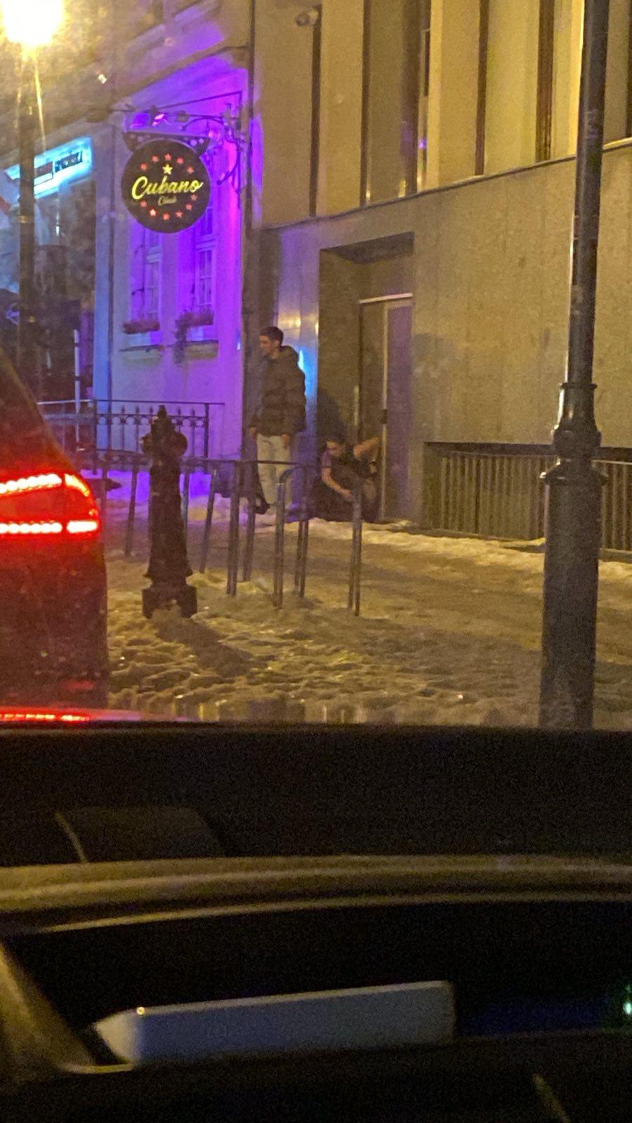 Młody mężczyzna defekujący na ulicy