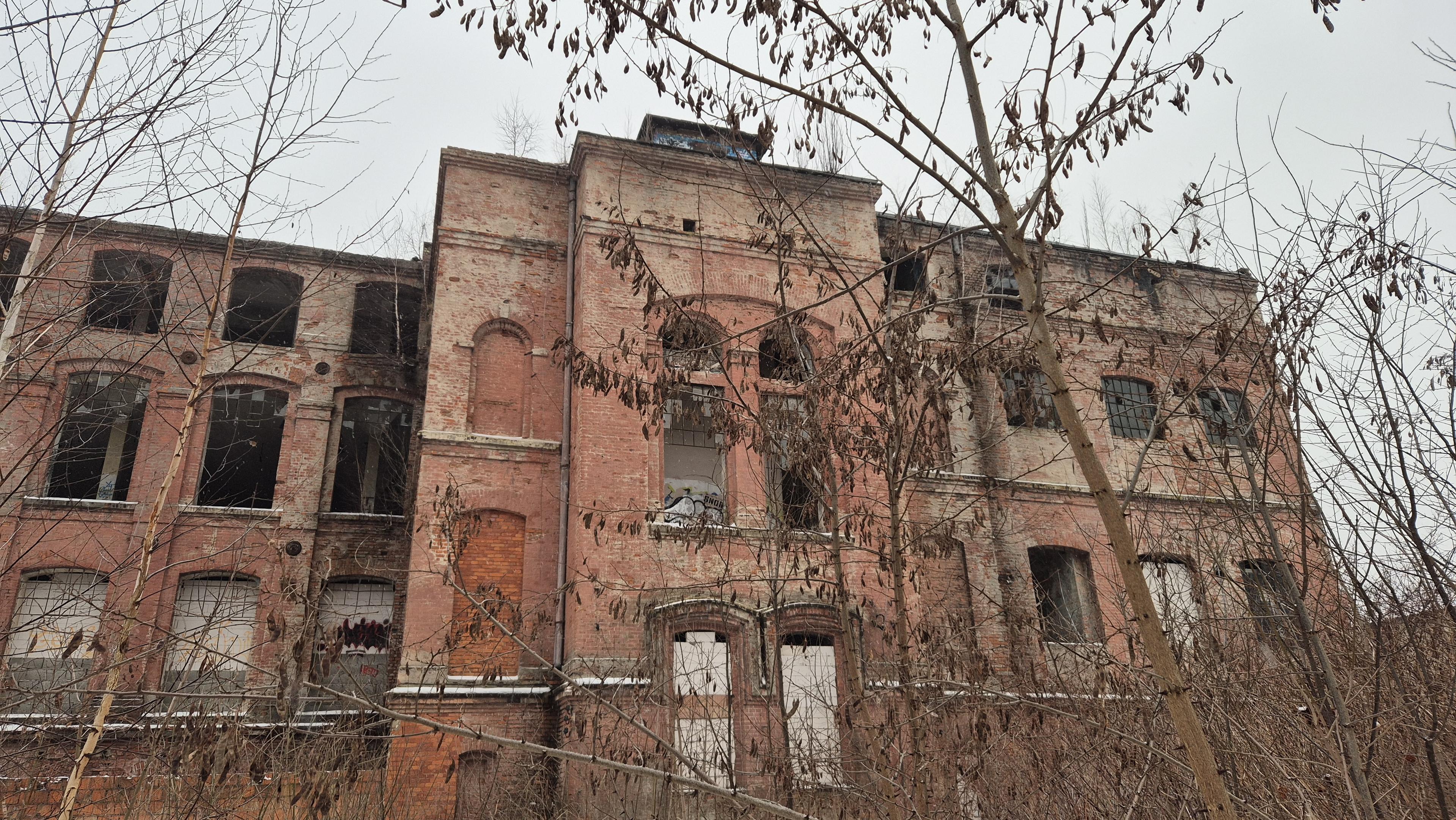 Zdewastowany i zarośnięty piętrowy budynek pofabryczny z cegły. Znajduje się tylko kilkadziesiąt metrów od tych z wcześniejszego wpisu.