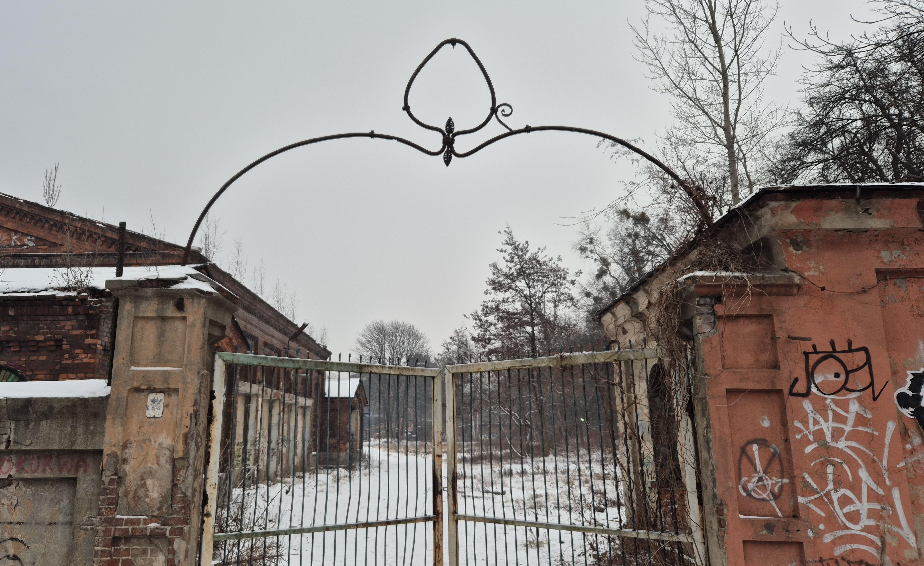 Dawna brama wjazdowa na końcowy odcinek bocznicy kolejowej zakładów włókienniczych. Nad bramą zachowana łukowata podpora z ozdobnym miejscem na zawieszenie (chyba) lampy, w kształcie podobnym do gruszki. Lampy nie ma, podobnie jak i samej bocznicy. Za bramą resztki zrujnowanych budynków.