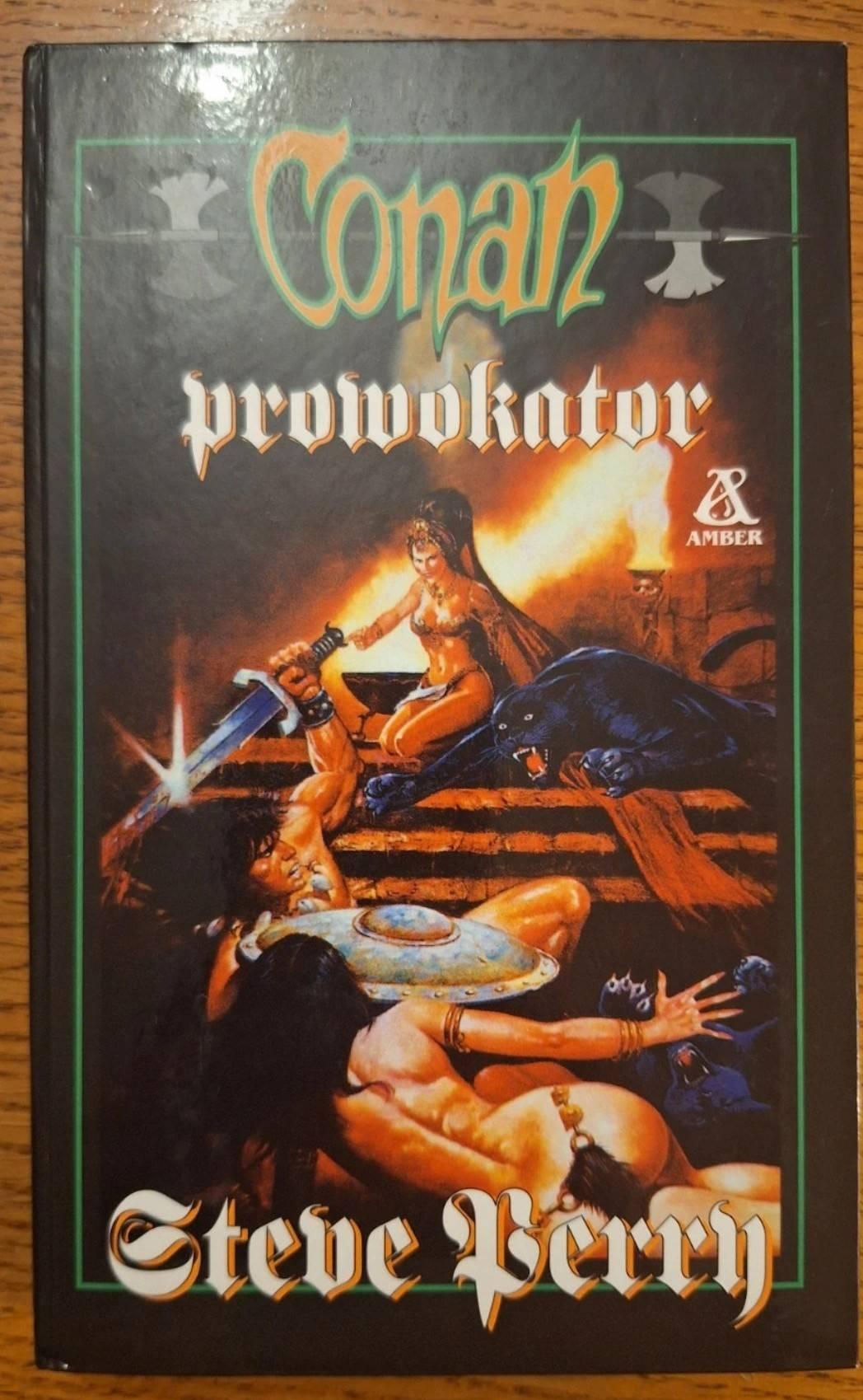 Okładka książki "Conan prowokator" w kiczowatym stylu grafik fantasy lat 90. W mocno przesyconych kolorach półnadzy bohaterowie i bohaterki płci obojga są zaangażowani w walkę na schodach, prężąc mięśnie. Całości dopełnia atakująca czarna pantera i świeczniki z czaszkami.