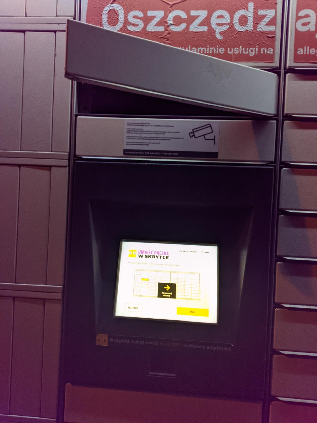 paczkomat InPost ze skrytką otwartą tuż nad ekranem (na wysokości głowy)