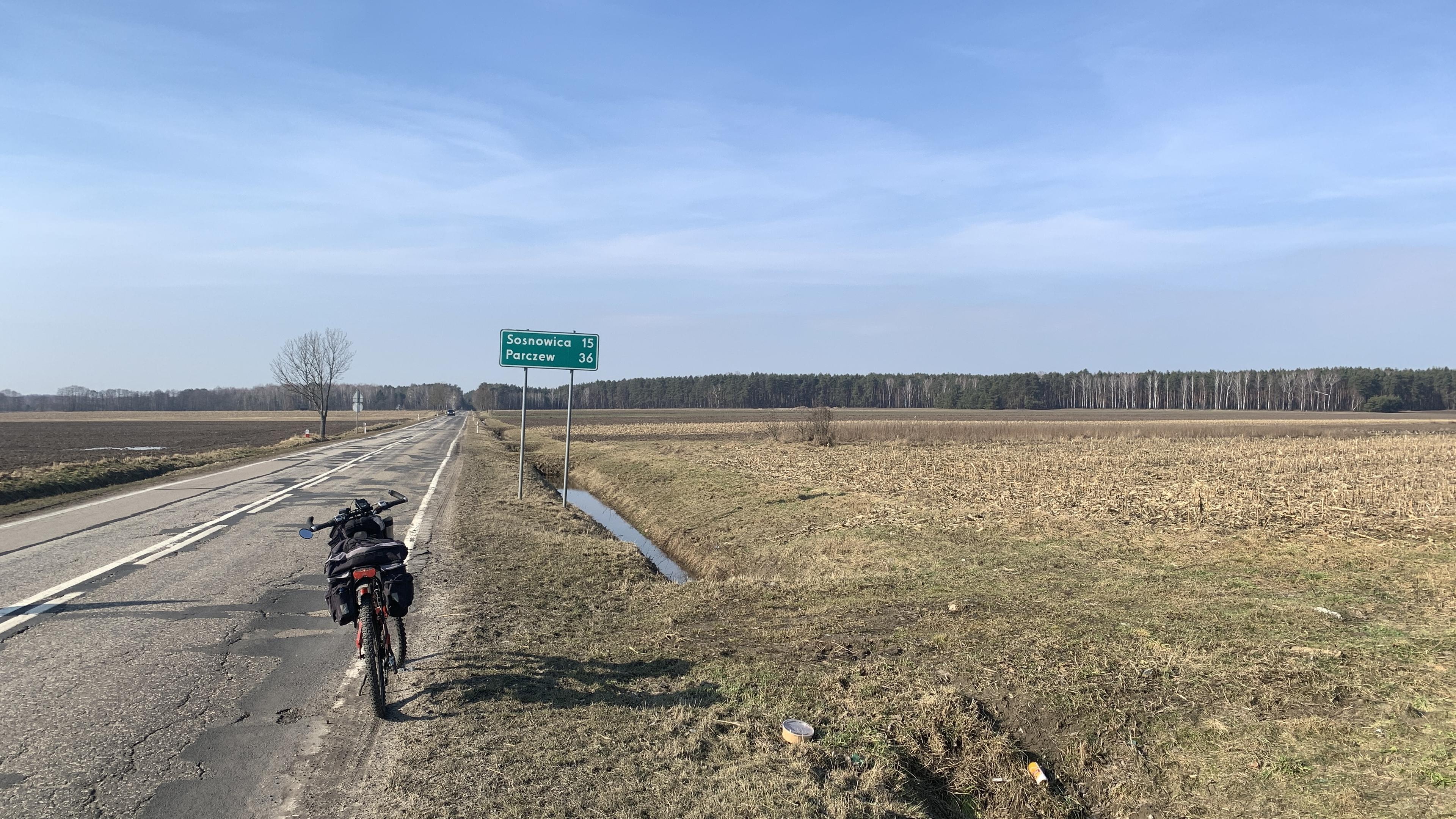 Podziurawiona droga powiatowa, zjazd na pole i drogowskaz:
Sosnowica 15
Parczew 45