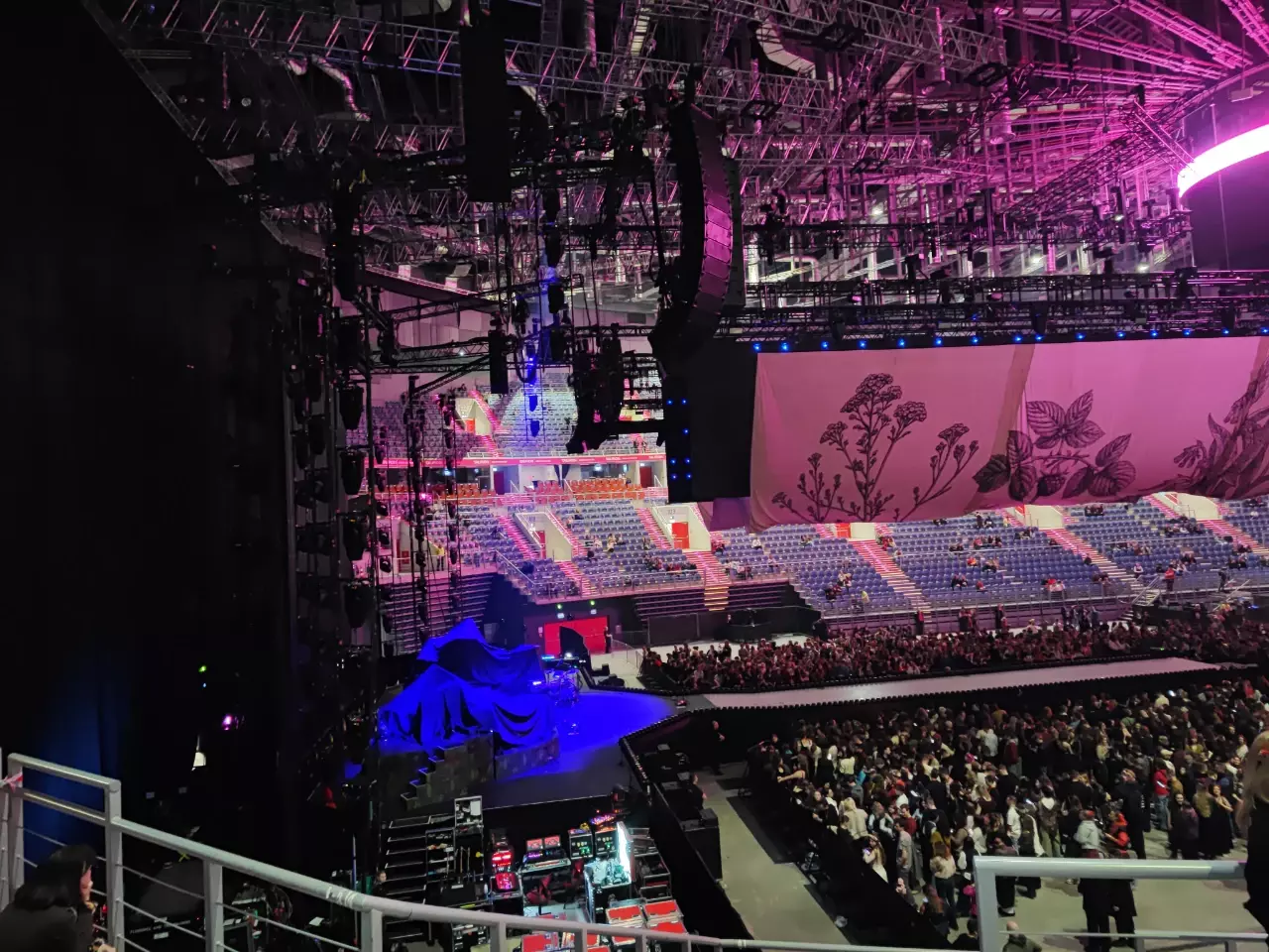 zdjęcie sceny w Tauron Arenie z trybun. pod sceną dużo ludzi.