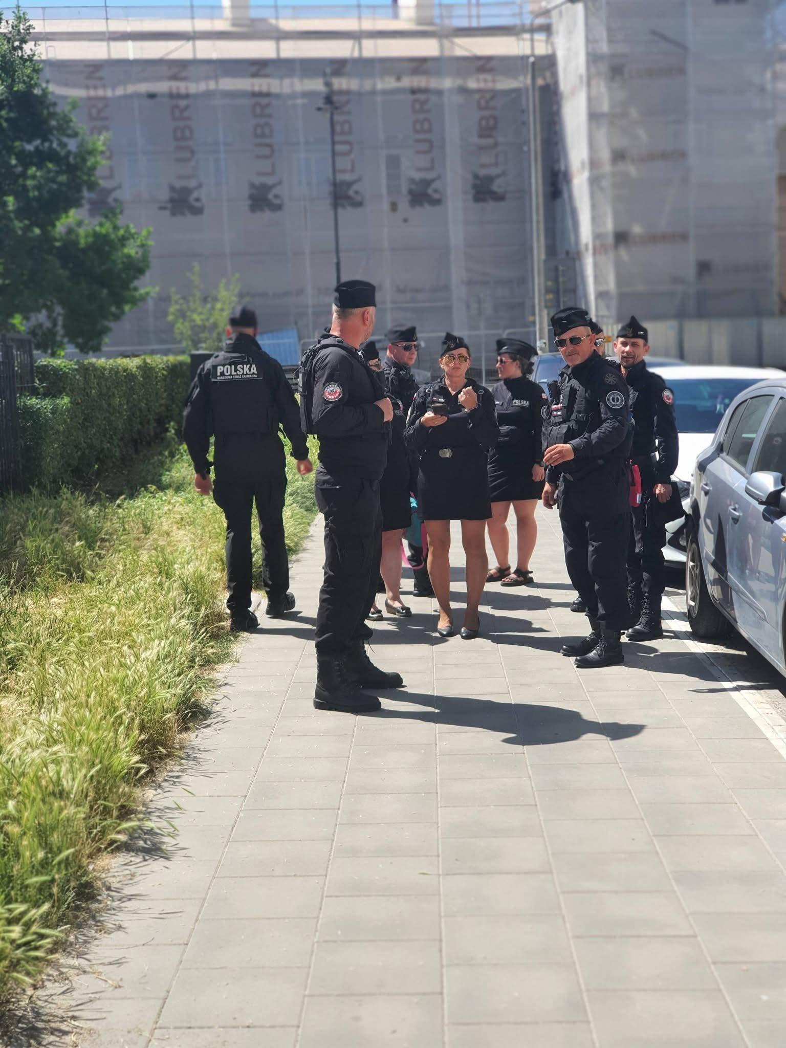 Jak na wcześniejszym zdjęciu, kilku mężczyzn i kilka kobiet na chodniku