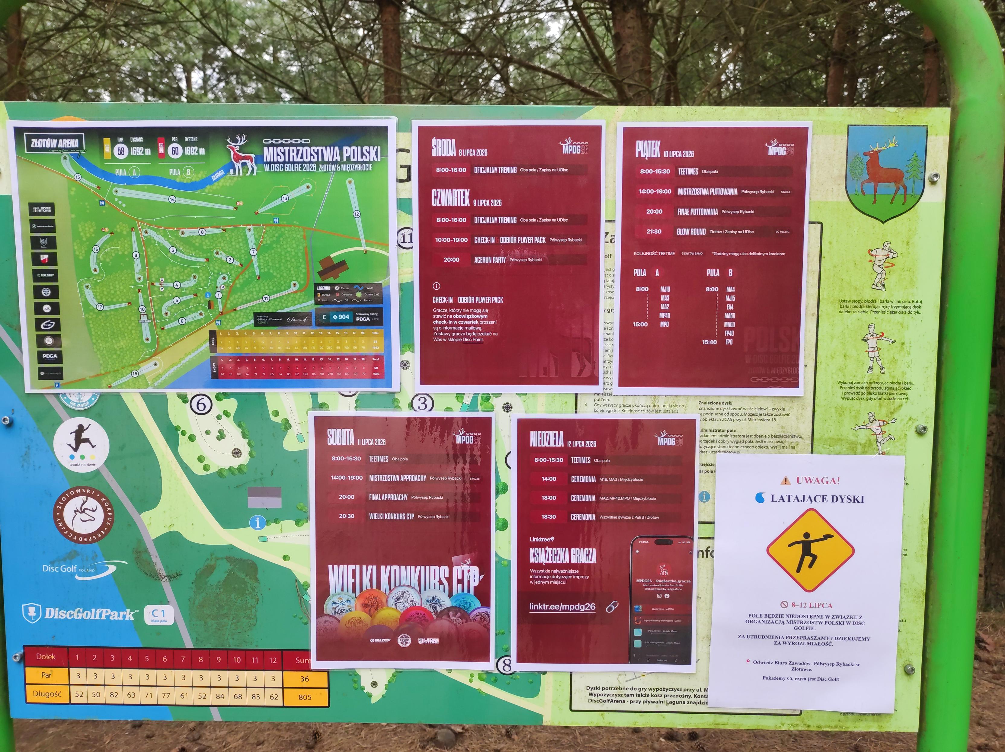 Tablica informacyjna z mapą pola i planem mistrzostw od środy do niedzieli.